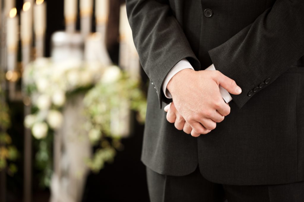 man or mortician at funeral mourning Arranging a funeral Newcastle